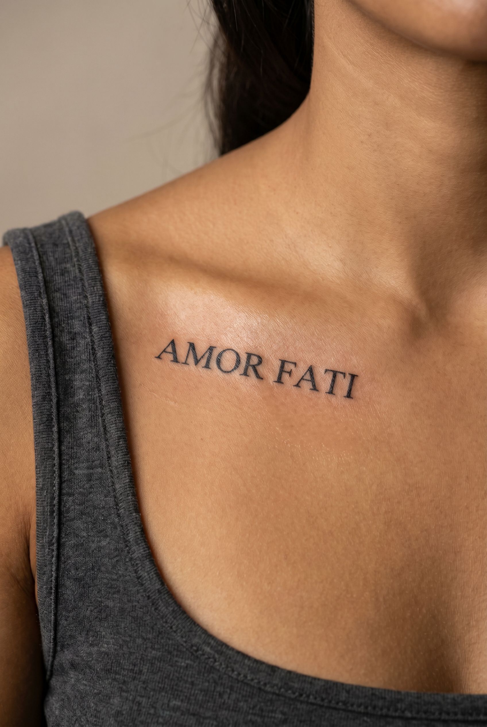 Tatouage de la phrase latine Amor fati sur la clavicule