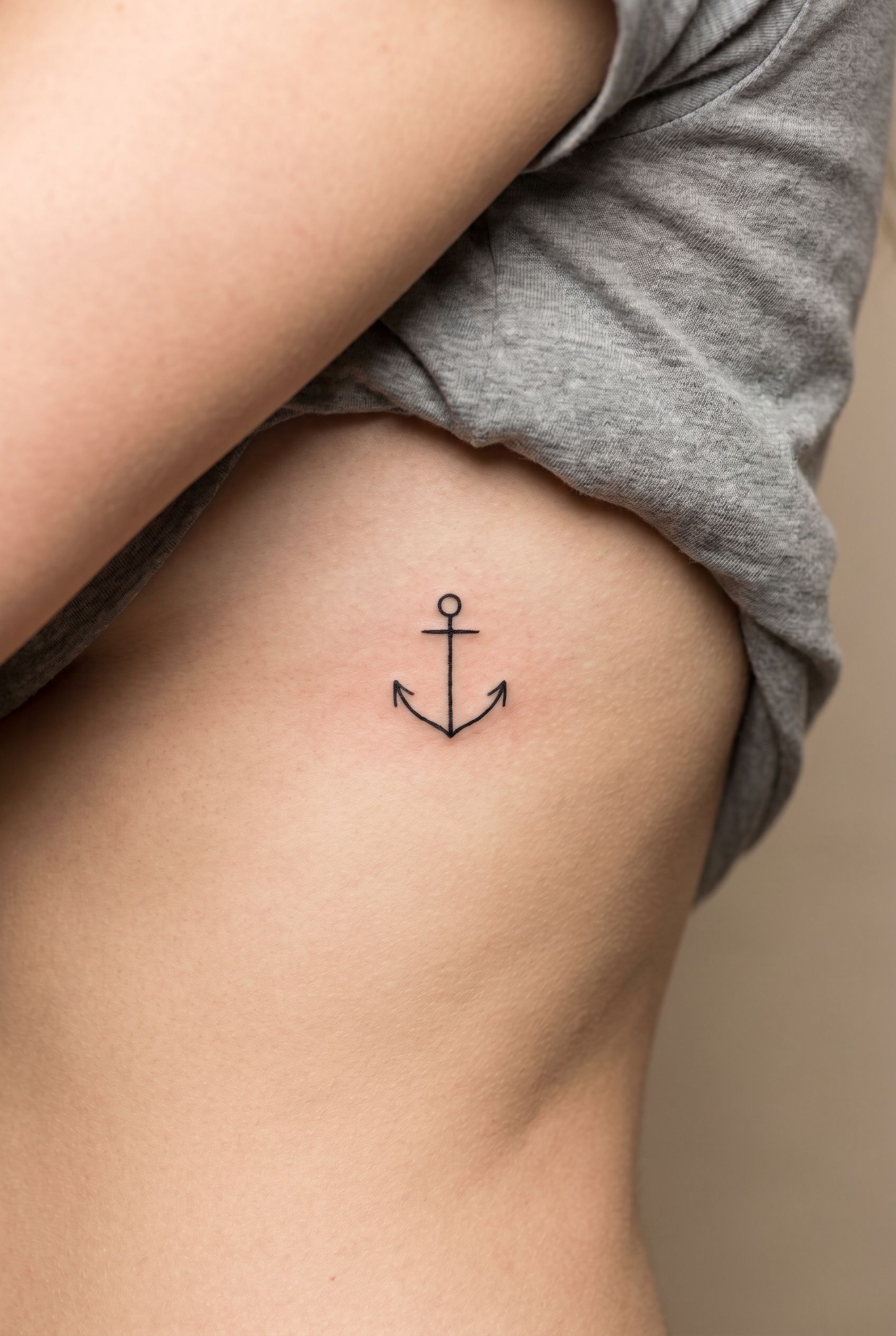 Tatouage d'une ancre marine fine sur les côtes d'une femme
