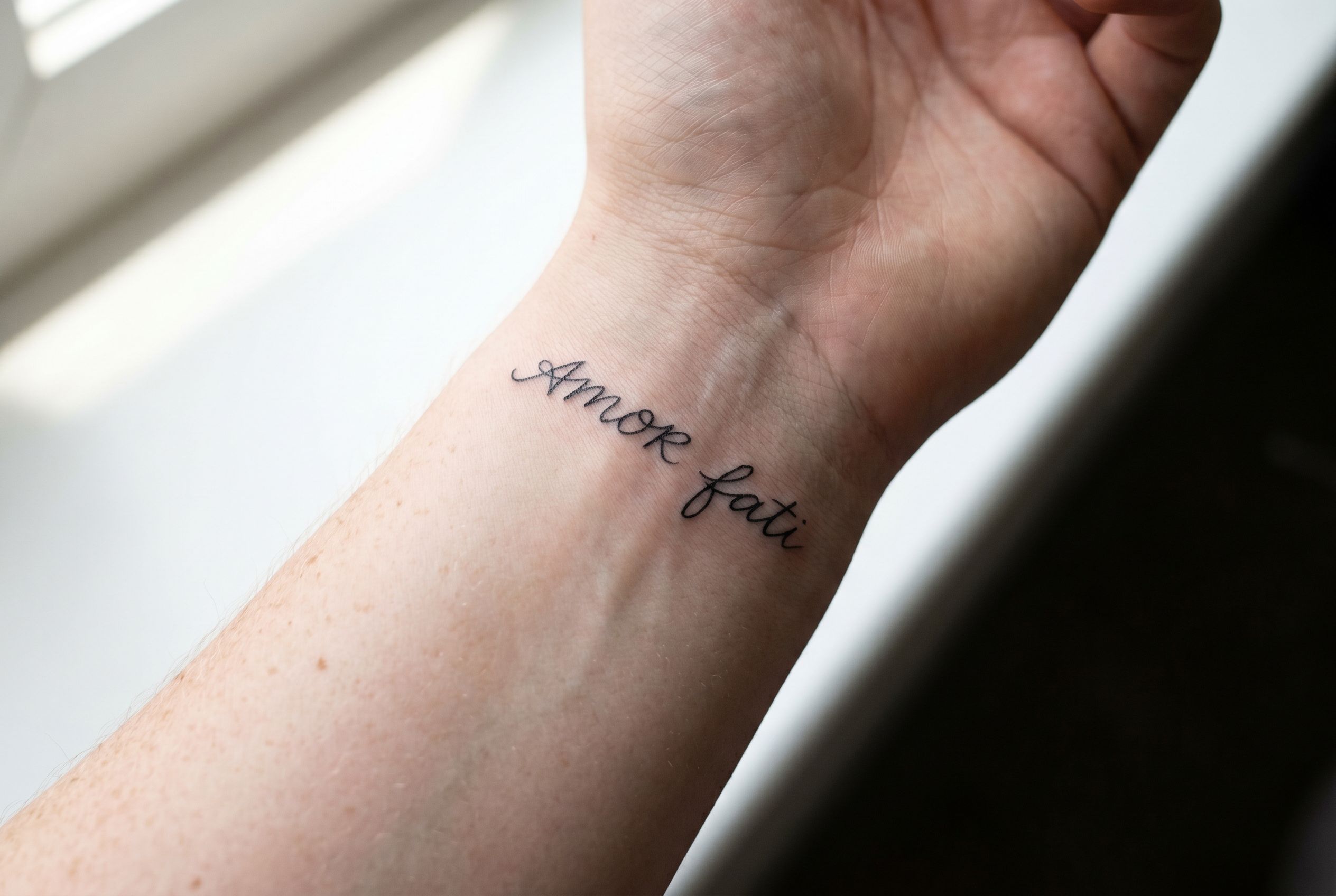 Tatouage carpe diem en lettrage fin sur l'avant-bras