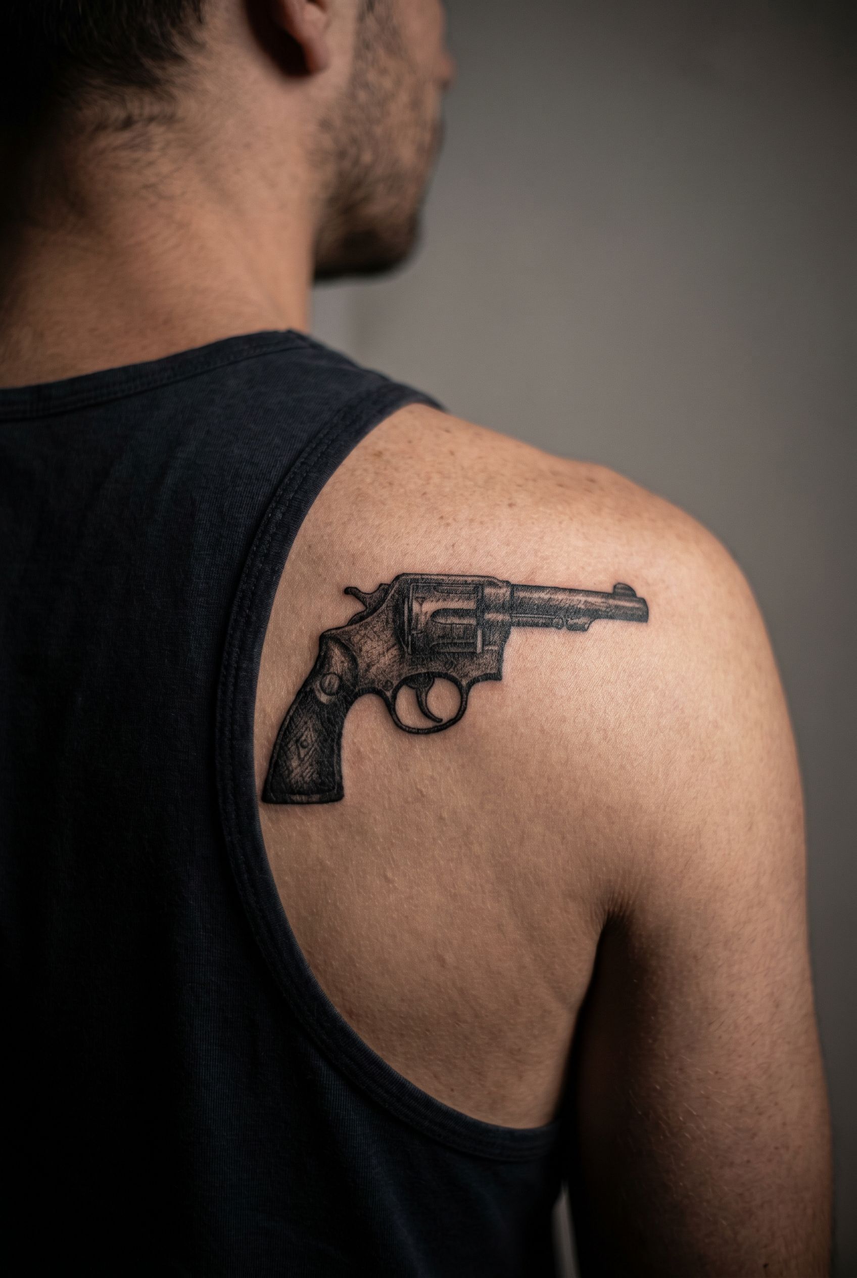 Tatouage réaliste du revolver Colt inspiré de Supernatural sur l'omoplate