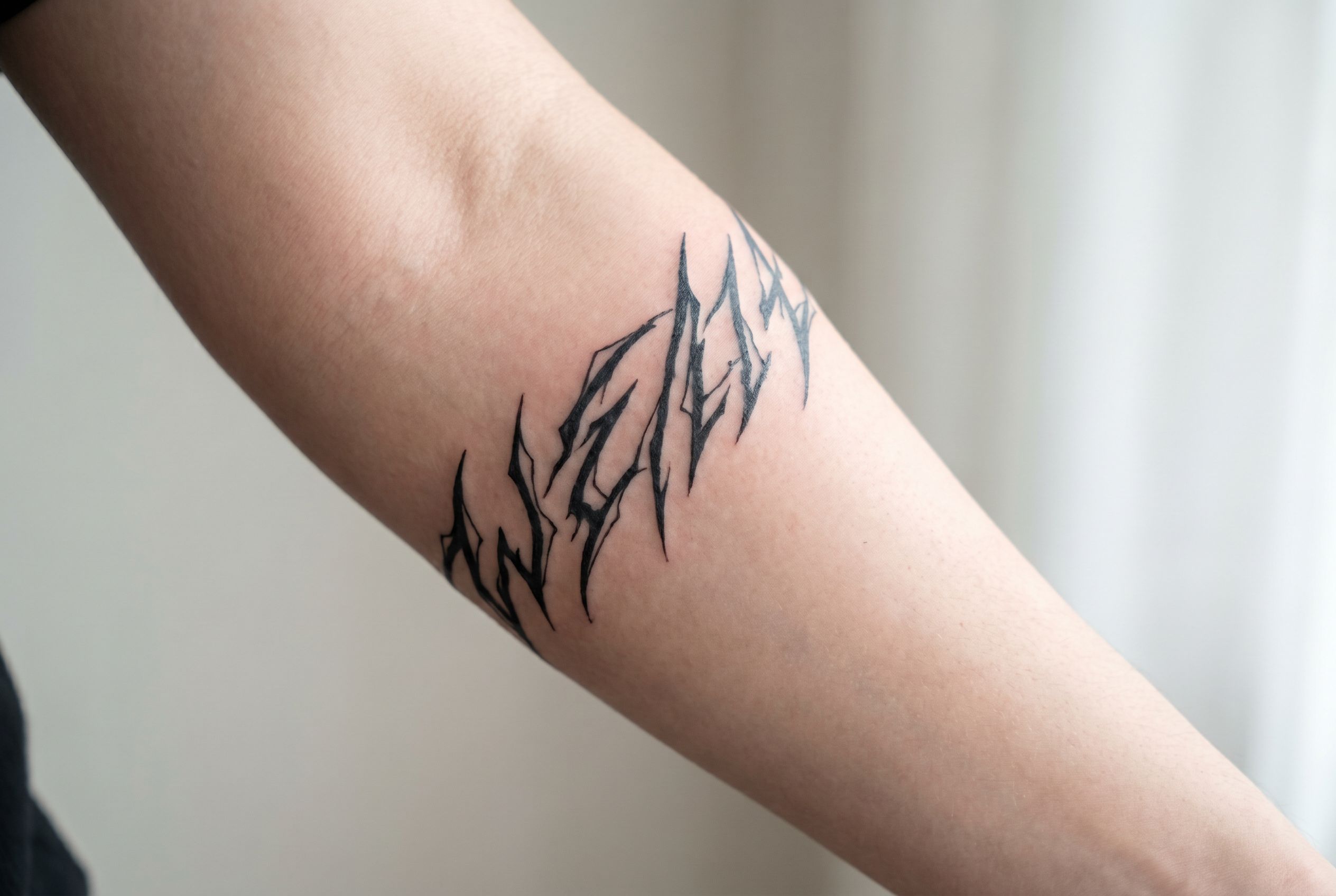Tatouage inspiré des marques de Sukuna sur l'avant-bras